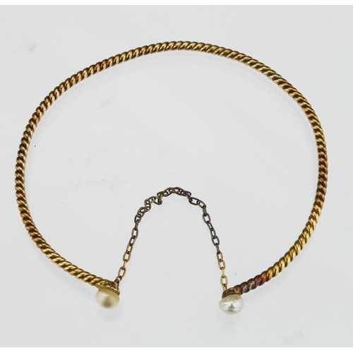 152 - Tests as 16/17ct yellow gold twisted wire sprung bangle with single pearl at each end, connected by ... 