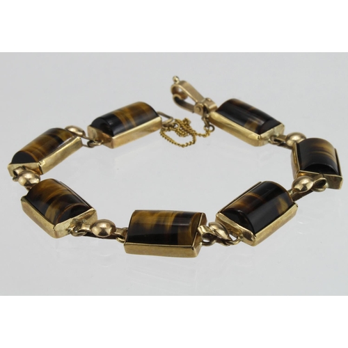 228 - 9ct yellow gold bracelet set with seven rectangular tigers eve barrel shaped stones measuring approx... 