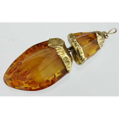 230 - Pendant featuring a large shaped amber drop with 9ct yellow gold textured cap setting, suspended fro... 