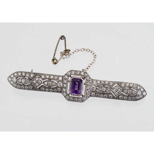 257 - 18ct white gold bar brooch set with a rectangular amethyst measuring approx. 7mm x 5mm, with a diamo... 