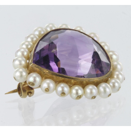 286 - 9ct yellow gold pear shaped brooch measuring approx. 2.5cm x 3cm, set with central amethyst and surr... 