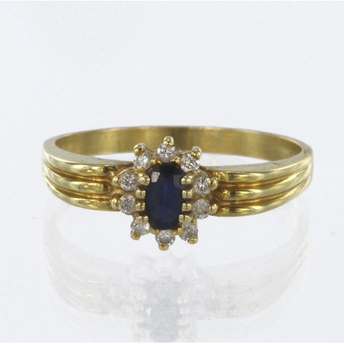 67 - 18ct yellow gold cluster ring set with a central oval sapphire measuring approx. 5mm x 3mm surrounde... 