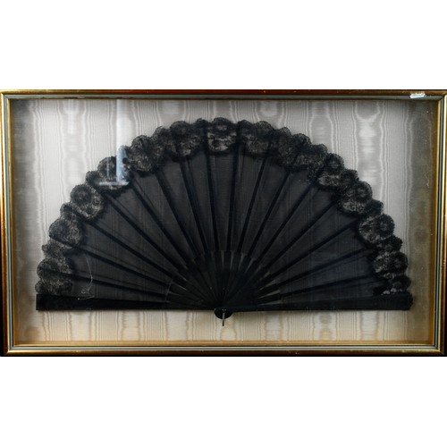 946 - Decorative fans- One black fan decorated with a painted image depicting a woman wearing a bustle ski... 