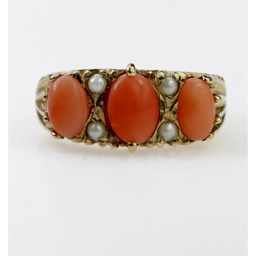 108 - 9ct yellow gold carved head ring set with three graduated coral cabochons and seed pearls, finger si... 