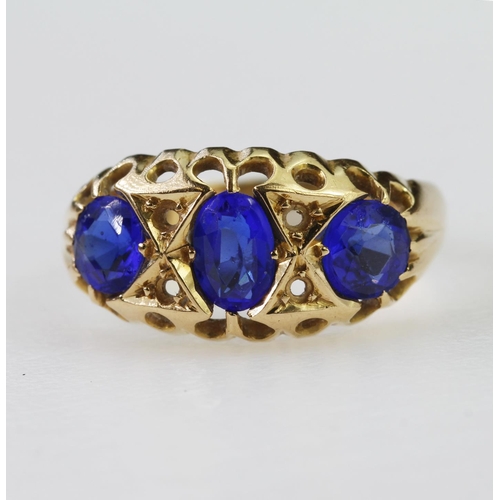 115 - 18ct yellow gold flared head ring set with three graduated blue paste stones, finger size M/N, weigh... 