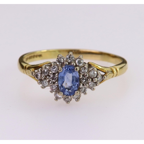 66 - 18ct yellow gold ring set with a central oval tanzanite measuring approx. 6mm x 4mm, surrounded by t... 