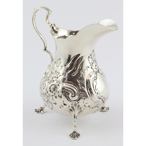 743 - Victorian embossed silver cream jug in the Georgian taste on three feet, hallmarked WRS London, 1856... 