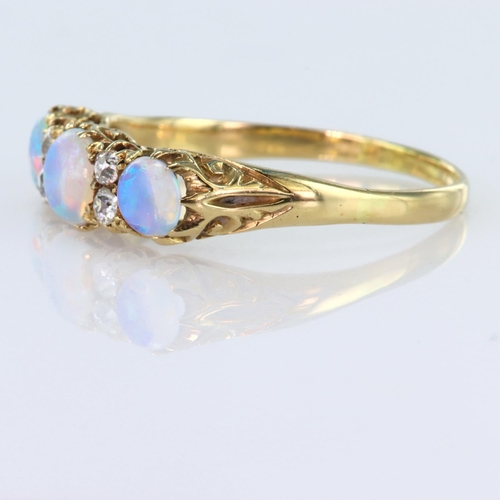 103 - 18ct yellow gold carved head ring set with three graduated round opal cabochons spaced by four round... 