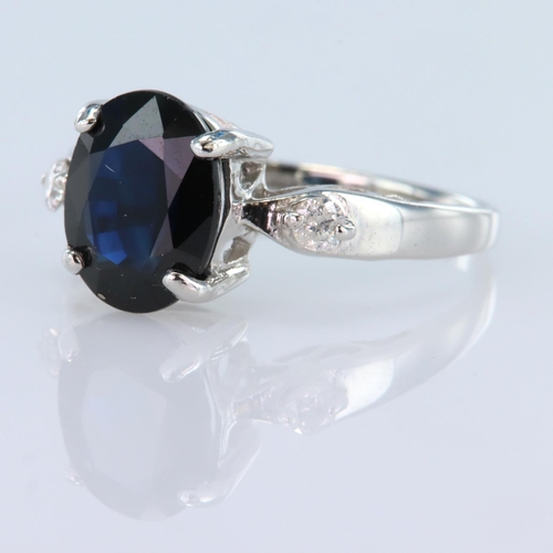 138 - 9ct white gold ring set with a central oval sapphire measuring approx. 10mm x 7.5mm, with a round br... 