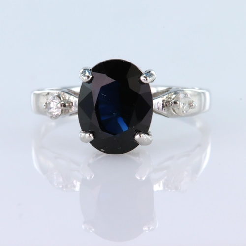 138 - 9ct white gold ring set with a central oval sapphire measuring approx. 10mm x 7.5mm, with a round br... 