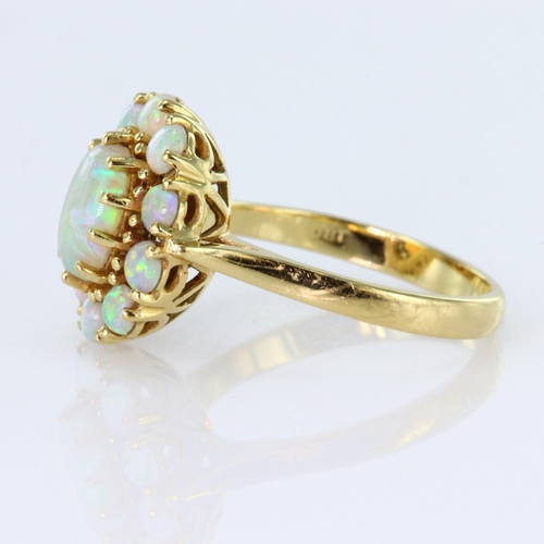 150 - 18ct yellow gold ring featuring a central oval opal cabochon measuring approx. 8mm x 6mm, surrounded... 