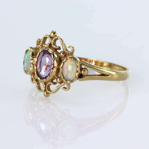 158 - 9ct yellow gold filigree ring set with a central oval amethyst measuring approx. 6mm x 4mm, and two ... 