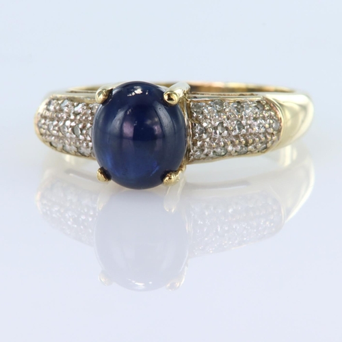 19 - 9ct yellow gold ring set with an oval sapphire cabochon measuring approx. 8mm x 7mm, with thirteen r... 