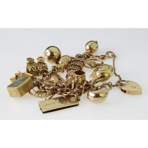 227 - 9ct yellow gold solid charm bracelet with padlock clasp and safety chain, featuring fifteen assorted... 