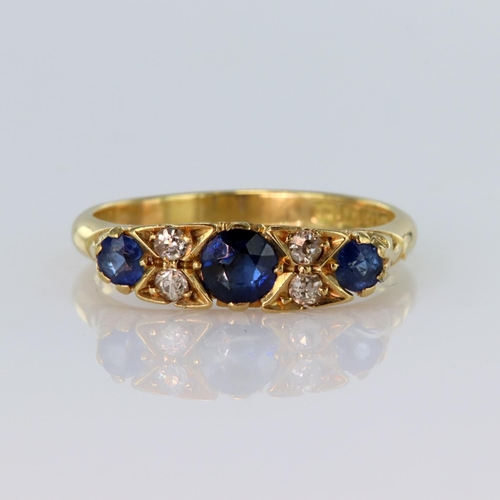 23 - 18ct yellow gold carved head ring set with three graduated sapphires divided by four round old cut d... 