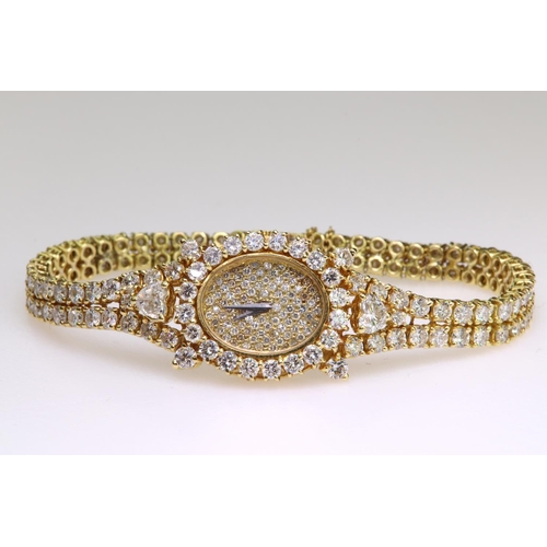 581 - 18ct yellow gold diamond set mechanical wind cocktail watch comprising a two row diamond set bracele... 