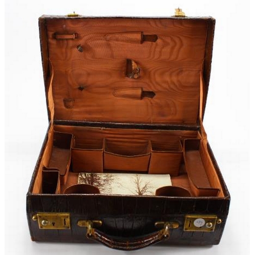 876 - Crocodile skin suitcase. With brass lock plates and catches. With a leather lined interior complete ... 