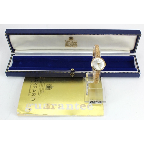 303 - Ladies 9ct cased wristwatch by Garrard on a 9ct bracelet, presentationally engraved on the back, wat... 