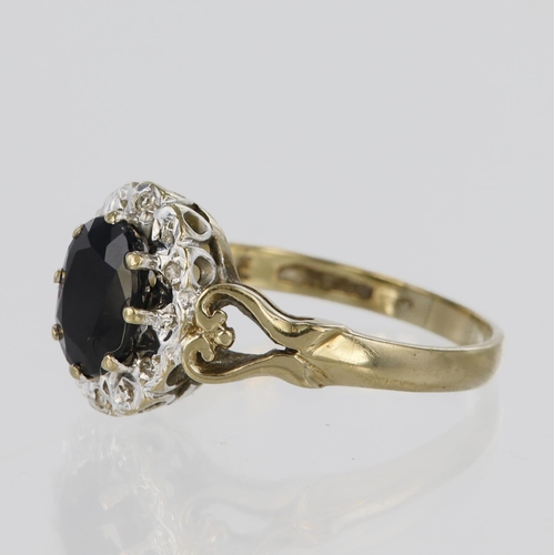 73 - 9ct yellow gold cluster ring set with a central claw set oval sapphire measuring approx. 7mm x 5mm s... 