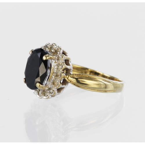 103 - 9ct yellow gold cluster ring set with a central oval sapphire measuring approx. 6mm x 4mm, surrounde... 