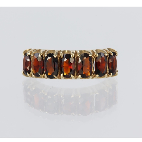 118 - 9ct yellow gold half eternity ring set with seven oval garnets measuring approx. 5mm x 3.5mm, all cl... 