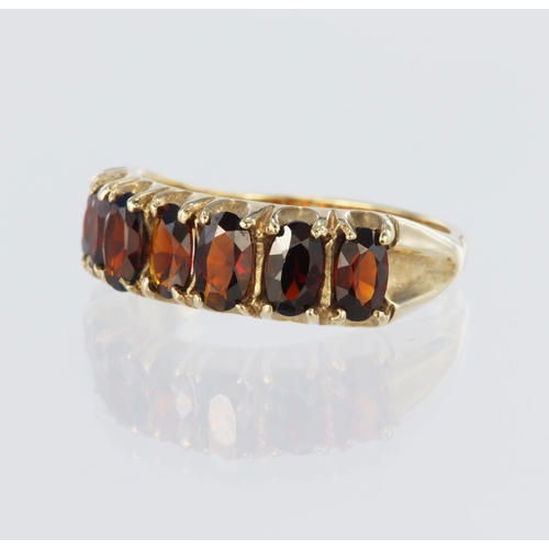 118 - 9ct yellow gold half eternity ring set with seven oval garnets measuring approx. 5mm x 3.5mm, all cl... 