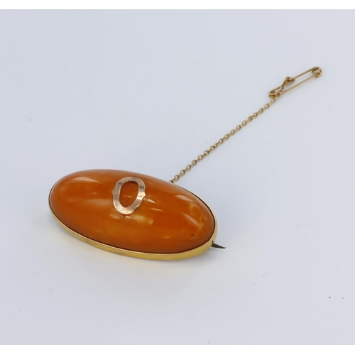 122 - 9ct yellow gold brooch set with an elongated oval of amber measuring approx. 42mm x 19mm, with safet... 