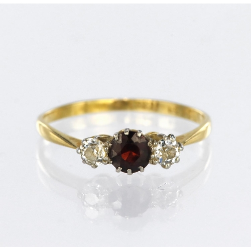 127 - 18ct yellow gold three stone ring set with a central round garnet measuring approx. 4.5mm diameter, ... 