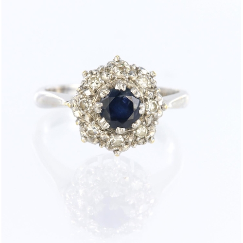 35 - 18ct white gold cluster ring set with a central round sapphire measuring approx. 5mm diameter surrou... 