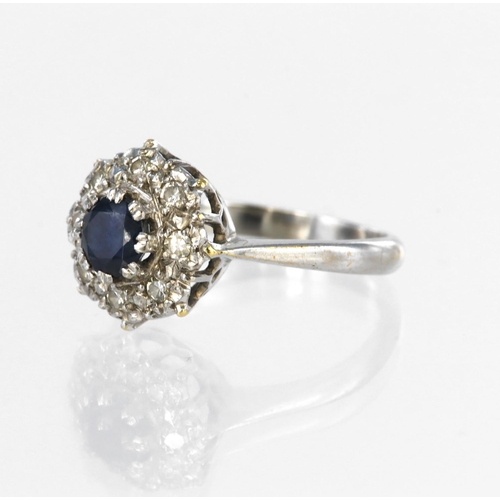 35 - 18ct white gold cluster ring set with a central round sapphire measuring approx. 5mm diameter surrou... 