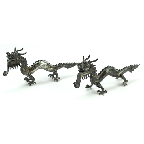 554 - Menu Holders. Pair of Chinese white metal menu holders, depicting dragons, height 65mm, length 13.5c... 