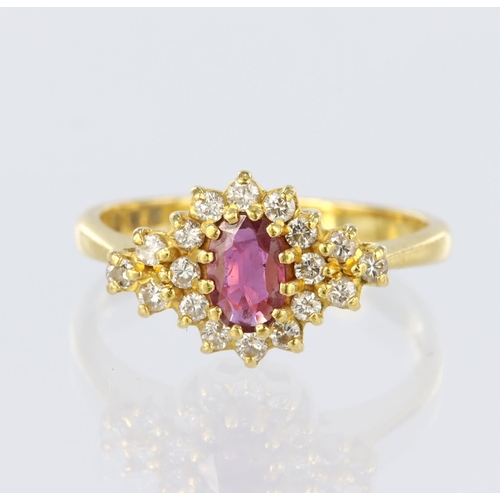 6 - 22ct yellow gold ring set with a central oval ruby measuring approx. 6mm x 4mm, surrounded by twelve... 