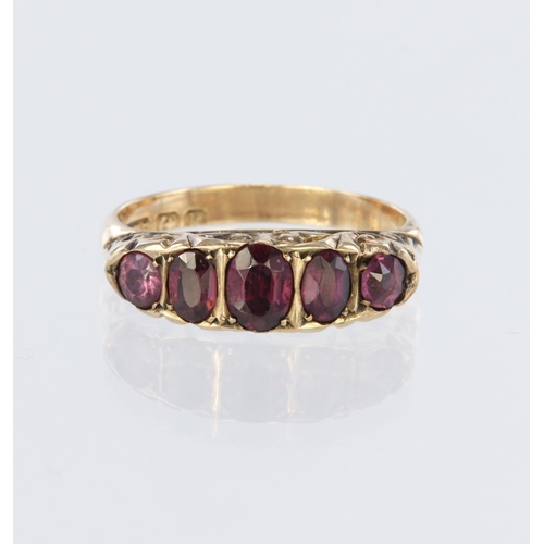 71 - 9ct rose gold carved head ring set with five graduated almondine garnets, measuring approx. 5.5mm x ... 