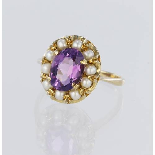 87 - 9ct yellow gold cluster ring featuring a central oval amethyst measuring approx. 10mm x 7mm, surroun... 