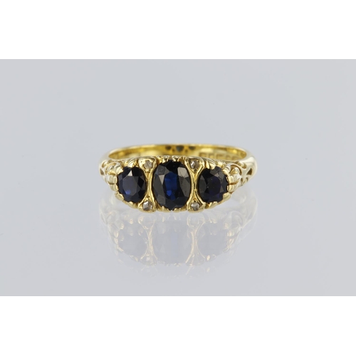 89 - 18ct yellow gold carved head ring set with three graduated oval sapphires spaced by four diamond poi... 