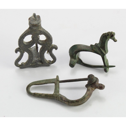 388 - Antiquity. Three ancient bronze brooches, including one depicting a horse, largest length 45mm appro... 