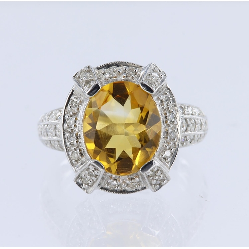 131 - 14ct white gold dress ring set with a central oval citrine measuring approx. 12mm x 10mm, surrounded... 