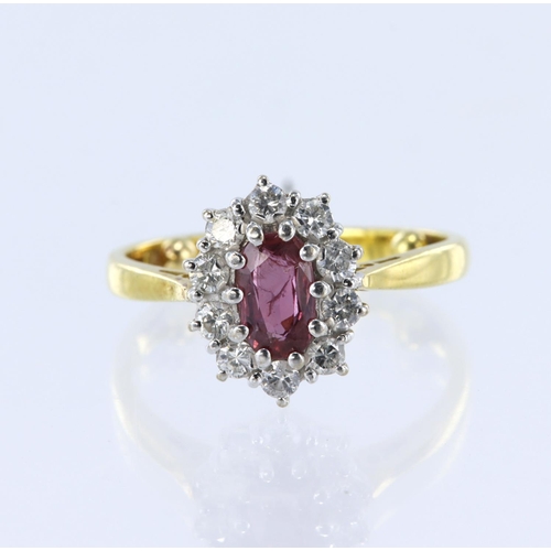 167 - 18ct yellow gold cluster ring featuring a central oval ruby measuring approx. 7mm x 4.5mm, surrounde... 