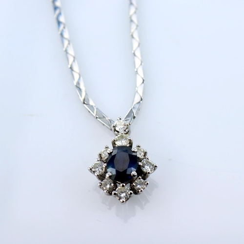 240 - 18ct white gold necklace featuring a central oval sapphire measuring approx. 7mm x 6mm, surrounded b... 