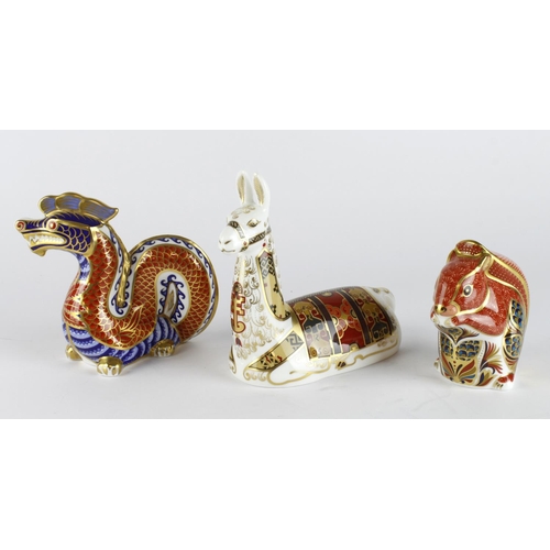 984 - Royal Crown Derby. A group of three Royal Crown Derby animal paperweights, comprising Dragon, Llama ... 