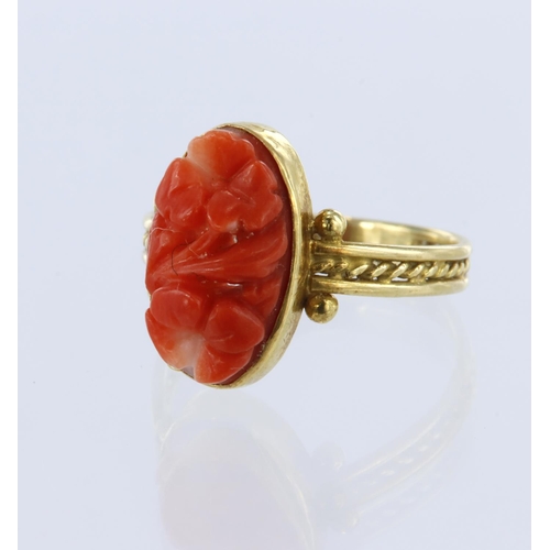10 - Yellow gold (tests 18ct) coral ring, floral carved coral measures 11.7mm x 6.7mm x 3.6mm, bezel sett... 