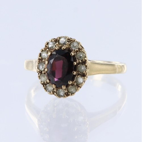 73 - 9ct yellow gold cluster ring, set with one oval cut red paste stone and surrounded by clear paste st... 