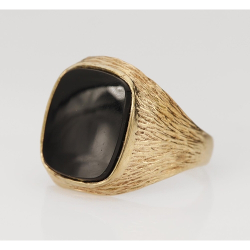 133 - 9ct yellow gold onyx signet ring, cushion shaped onyx measures 14mm x 12mm, bark finished shoulders,... 