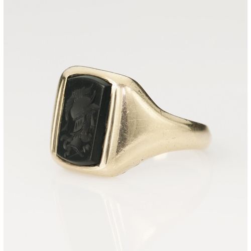 139 - Yellow gold (tests 9ct) onyx intaglio signet ring, rectangular shaped onyx engraved with a warrior h... 