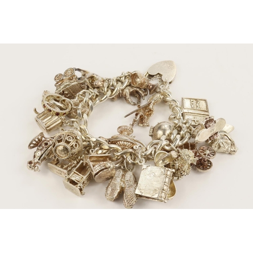 378 - Silver / white metal charm bracelet with a good variety of charms attached. Total weight 127.6g