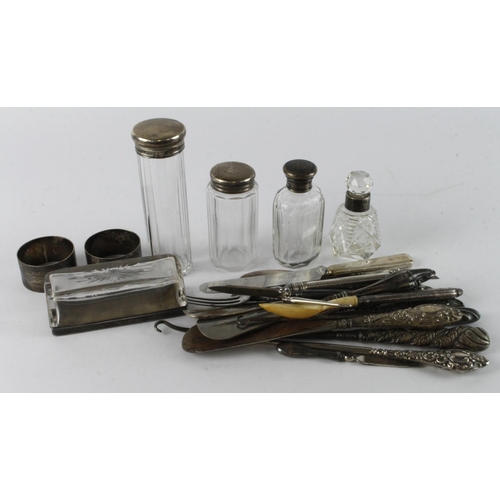 902 - Silver. A collection of various silver and white metal napkin rings, lidded glass jars, button hooks... 