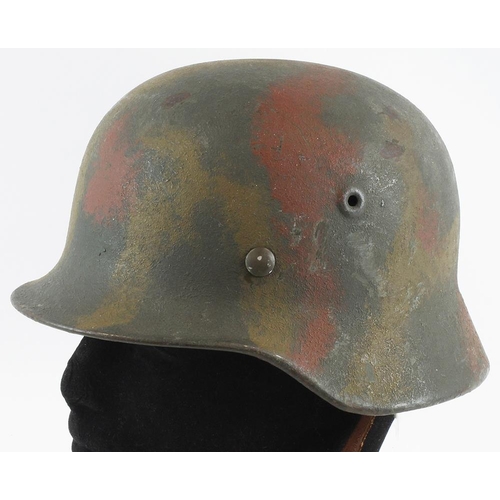 250 - German M35 pattern camo helmet complete with lining and chin strap.