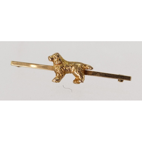 522 - Yellow gold (tests 15ct) springer spaniel dog bar brooch, bar length 51mm, weight 7g.