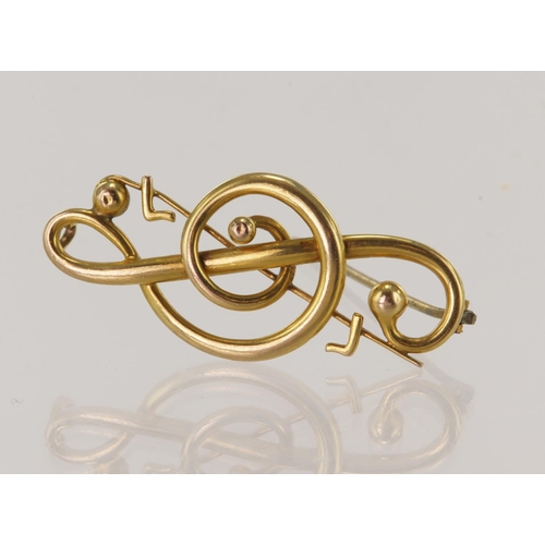 538 - Yellow gold (tests 15ct) treble clef brooch, length 40mm, weight 4.9g.