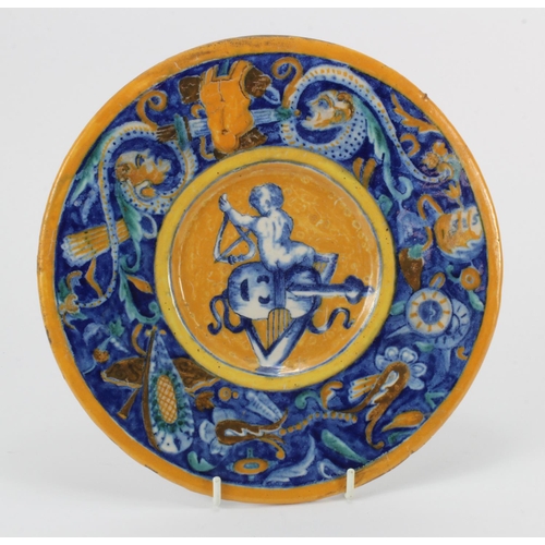 1136 - Italian majolica plate, depicting a boy sat upon musical instruments, diameter 24cm approx.